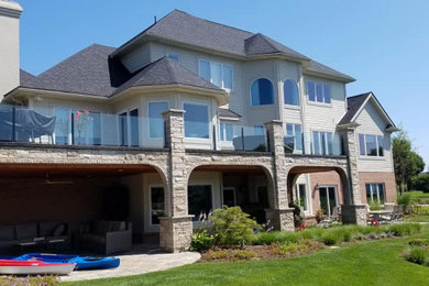 Inspiration for a large modern gray three-story mixed siding house exterior remodel in Detroit with a shingle roof