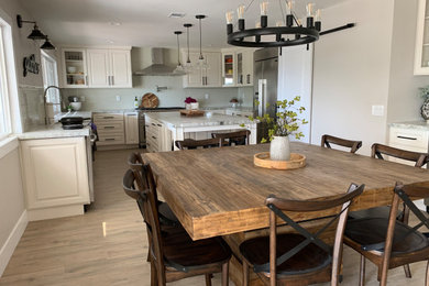 Example of a large transitional light wood floor and brown floor kitchen/dining room combo design in Orange County with gray walls, a standard fireplace and a stone fireplace
