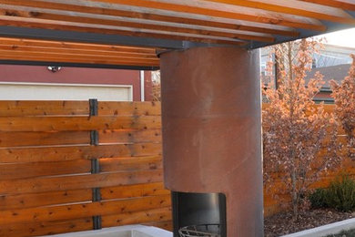 Example of a large minimalist backyard patio design in Denver with a fire pit and a pergola