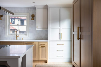 Mid-sized transitional light wood floor kitchen photo in Minneapolis with shaker cabinets, white cabinets, quartz countertops, white backsplash, ceramic backsplash, paneled appliances, an island and white countertops