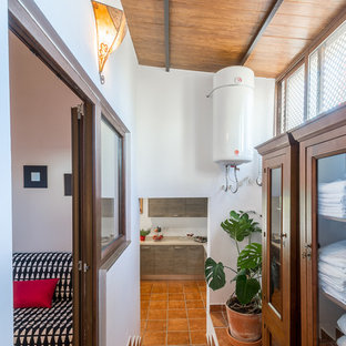 Idéer för att renovera en liten vintage hall, med vita väggar, klinkergolv i terrakotta och brunt golv