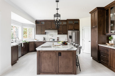 Inspiration for a large transitional u-shaped porcelain tile and white floor open concept kitchen remodel in Vancouver with an undermount sink, recessed-panel cabinets, dark wood cabinets, quartz countertops, white backsplash, ceramic backsplash, stainless steel appliances, an island and white countertops