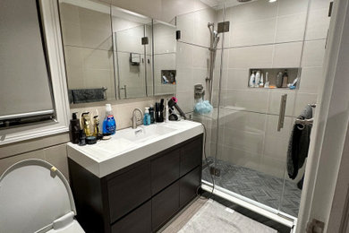 Inspiration for a mid-sized modern master beige tile and porcelain tile ceramic tile, brown floor and single-sink bathroom remodel in New York with flat-panel cabinets, dark wood cabinets, a one-piece toilet, quartz countertops, white countertops and a freestanding vanity