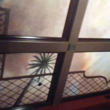 Mural of Moroccan sunset on coffered ceiling in home theater