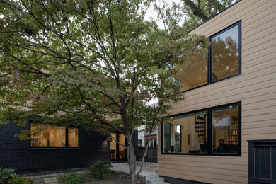 Ejemplo de fachada de casa beige minimalista grande de dos plantas con revestimiento de aglomerado de cemento, tejado plano y tablilla