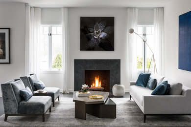 Contemporary open concept living room in New York with white walls, carpet, a standard fireplace, a stone fireplace surround and brown floor.