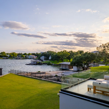 Modern Luxury Lakehouse Second-Floor Terrace with Glass Railing Overlooking Lake