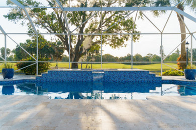 Modelo de piscina de tamaño medio rectangular en patio trasero con paisajismo de piscina y adoquines de piedra natural