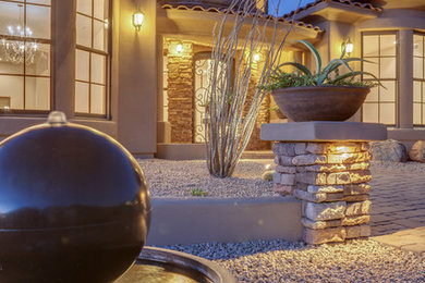 Large mediterranean brown one-story stucco exterior home idea in Phoenix