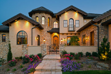 Photo of a mediterranean two-storey beige exterior in Denver with a gable roof.