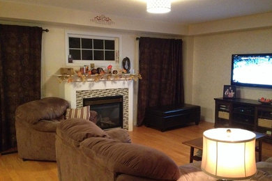 Example of a mid-sized classic open concept light wood floor and beige floor family room design in Toronto with beige walls, a standard fireplace, a tile fireplace and a wall-mounted tv