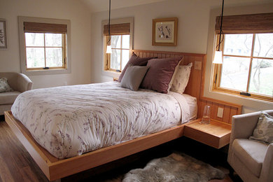 Example of a mid-sized trendy master medium tone wood floor bedroom design in New York with white walls