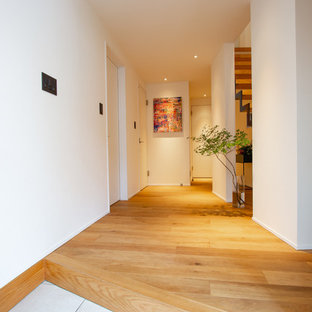 東京23区のアジアンスタイルのおしゃれな玄関ホール (白い壁、無垢フローリング) の写真