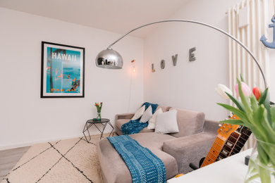 Esempio di un soggiorno moderno di medie dimensioni con pareti bianche, pavimento in laminato e pavimento grigio