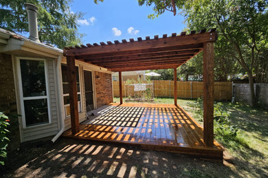 Diseño de patio tradicional de tamaño medio en patio trasero con pérgola
