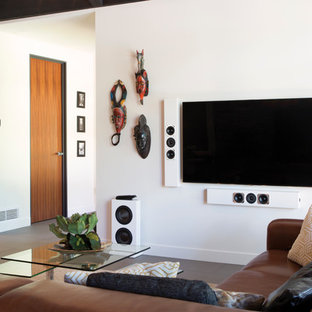 Idée de décoration pour une salle de cinéma design de taille moyenne et ouverte avec un mur blanc, un sol en contreplaqué et un téléviseur fixé au mur.