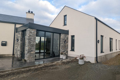 This is an example of a white contemporary bungalow front and render detached house in Other with a pitched roof, a shingle roof and a black roof.