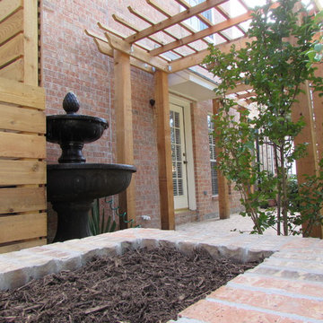 High function in a small side yard! Pergola, raised bed, mirrored wall, fountain