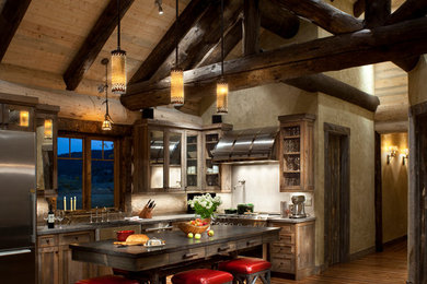Open concept kitchen - mid-sized rustic l-shaped medium tone wood floor open concept kitchen idea in Denver with a farmhouse sink, shaker cabinets, dark wood cabinets, stainless steel appliances, an island and granite countertops