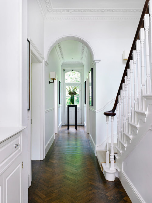 Classic hallway in London with white walls, dark hardwood flooring, a single front door, a white front door and brown floors.