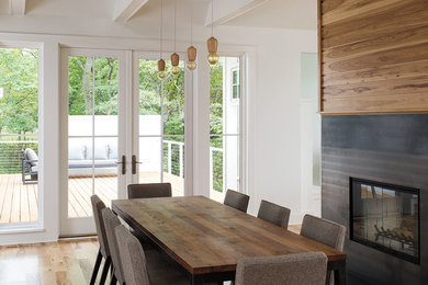 Inspiration for a mid-sized contemporary light wood floor and beige floor dining room remodel in Chicago with white walls, a standard fireplace and a tile fireplace
