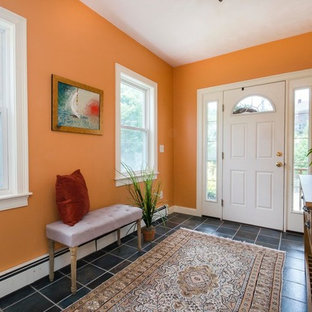 Пример оригинального дизайна интерьера: фойе среднего размера в морском стиле с оранжевыми стенами, полом из сланца, одностворчатой входной дверью, белой входной дверью и черным полом