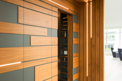 Huge trendy light wood floor, beige floor and wood wall hallway photo in Vancouver with white walls