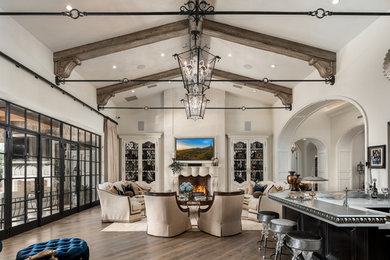 Inspiration for a huge open concept medium tone wood floor, brown floor, coffered ceiling and wall paneling living room remodel in Phoenix with a bar, white walls, a standard fireplace, a stone fireplace and a wall-mounted tv
