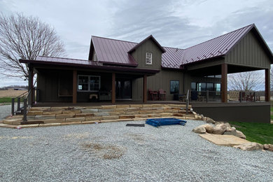 Mid-sized elegant brown two-story exterior home photo in Other with a metal roof