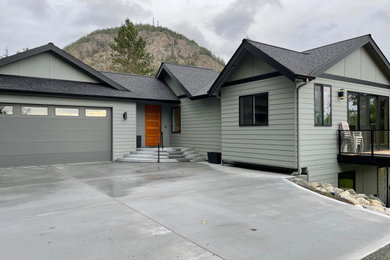 Inspiration for a green two-story house exterior remodel in Seattle with a shingle roof and a black roof
