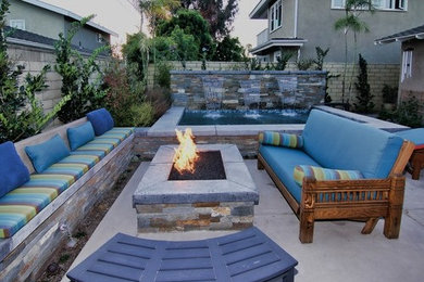 Example of a mid-sized transitional backyard concrete paver patio fountain design in Orange County with no cover