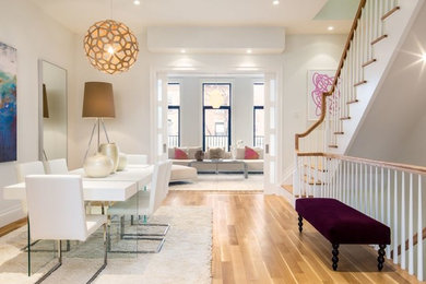 Large trendy light wood floor great room photo in New York with white walls