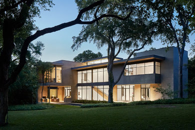 Example of a large trendy white two-story stone exterior home design in Dallas with a metal roof