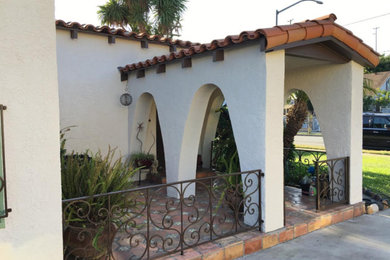 Inspiration for a mid-sized mediterranean white one-story stucco house exterior remodel in Los Angeles with a hip roof and a tile roof