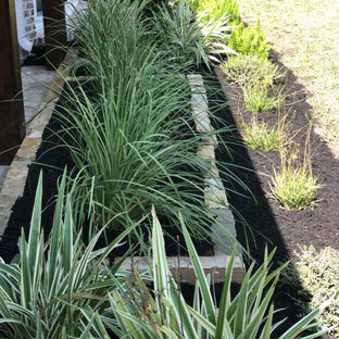Großer Eklektischer Vorgarten mit Blumenbeet, direkter Sonneneinstrahlung und Mulch in Houston