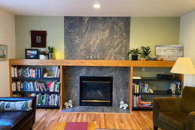 シアトルにあるトラディショナルスタイルのおしゃれなリビング (緑の壁、淡色無垢フローリング、標準型暖炉、タイルの暖炉まわり) の写真