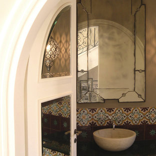 Medium sized world-inspired cloakroom in Other with flat-panel cabinets, light wood cabinets, multi-coloured tiles, terracotta tiles, beige walls, travertine flooring, a vessel sink, marble worktops, beige floors and black worktops.