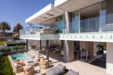 Mittelgroße, Überdachte Moderne Terrasse hinter dem Haus mit Glasgeländer in Orange County