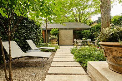 This is an example of a small contemporary backyard partial sun formal garden for spring in Toronto with with waterfall and natural stone pavers.