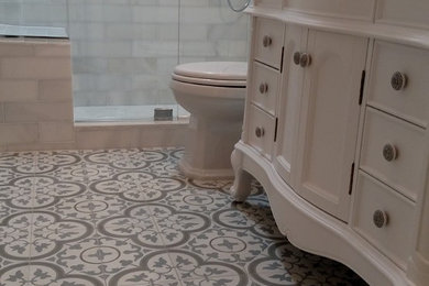 На фото: ванная комната среднего размера в классическом стиле с душем в нише, унитазом-моноблоком, белой плиткой, плиткой кабанчик, серыми стенами, полом из цементной плитки, врезной раковиной, мраморной столешницей, фасадами с утопленной филенкой и белыми фасадами с