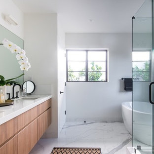 Immagine di una stanza da bagno minimalista di medie dimensioni con ante lisce, ante in legno scuro, vasca freestanding, doccia aperta, pistrelle in bianco e nero, piastrelle di marmo, pareti bianche, pavimento in marmo, lavabo sottopiano, top in saponaria, pavimento bianco, porta doccia a battente e top bianco
