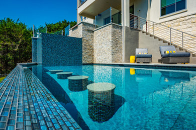Large trendy backyard rectangular pool photo in Austin