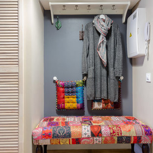 Bild på en liten eklektisk hall, med grå väggar, laminatgolv, en enkeldörr och en blå dörr