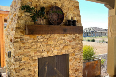Cette image montre un grand xéropaysage arrière traditionnel avec une cheminée et des pavés en pierre naturelle.