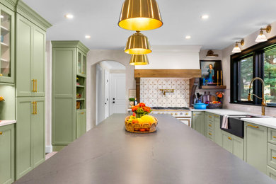 Large french country u-shaped porcelain tile and beige floor enclosed kitchen photo in New York with a farmhouse sink, recessed-panel cabinets, green cabinets, quartz countertops, beige backsplash, cement tile backsplash, paneled appliances, an island and black countertops