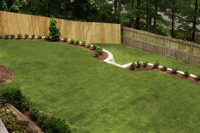 Photo of a large traditional backyard mulch retaining wall landscape in Birmingham.