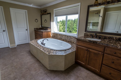 Inspiration for a large modern master multicolored tile and pebble tile porcelain tile drop-in bathtub remodel in Seattle with an undermount sink, recessed-panel cabinets, medium tone wood cabinets, marble countertops and beige walls