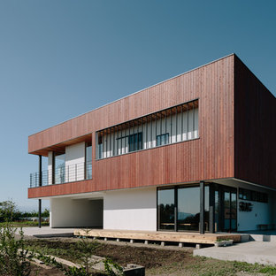 他の地域のコンテンポラリースタイルのおしゃれな二階建ての家 (茶色い外壁、陸屋根) の写真