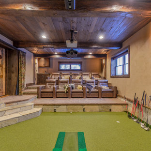 Réalisation d'un grand sous-sol chalet semi-enterré avec salle de cinéma, un mur beige, aucune cheminée, un sol vert et un plafond en lambris de bois.