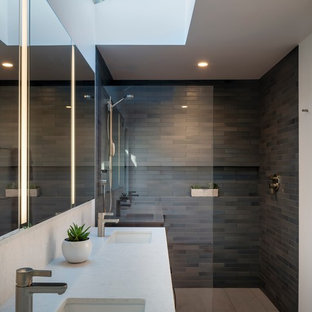 Новые идеи обустройства дома: большая главная ванная комната в современном стиле с плоскими фасадами, фасадами цвета дерева среднего тона, душем без бортиков, керамогранитной плиткой, полом из керамогранита, врезной раковиной, столешницей из искусственного кварца, серым полом, открытым душем и белой столешницей